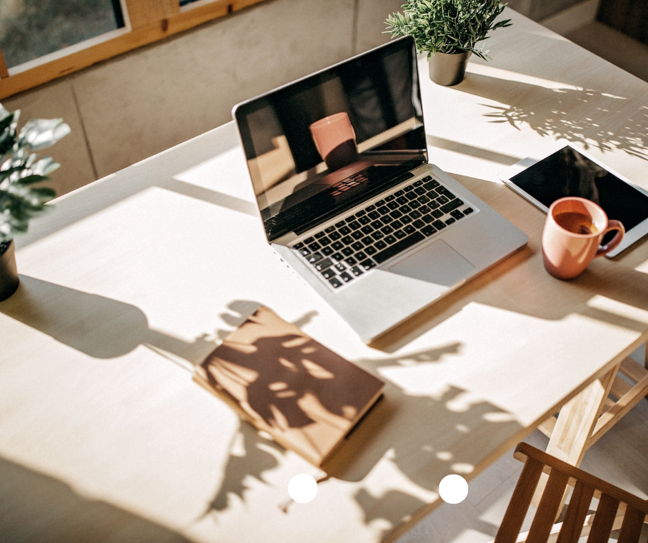 Laptop on the desk with a cup of coffee and a journal