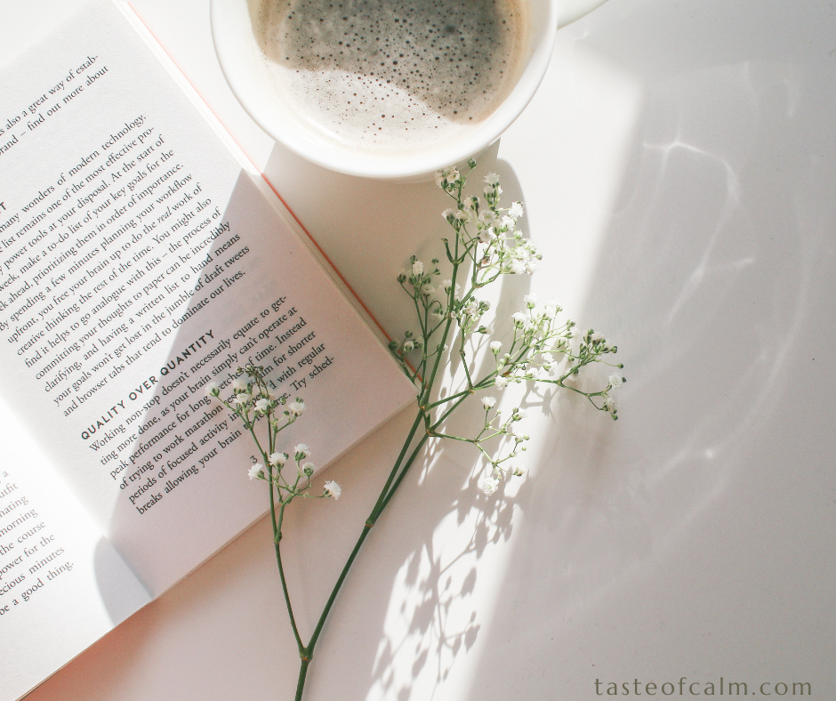 An opened book on the desk with a cup of coffee