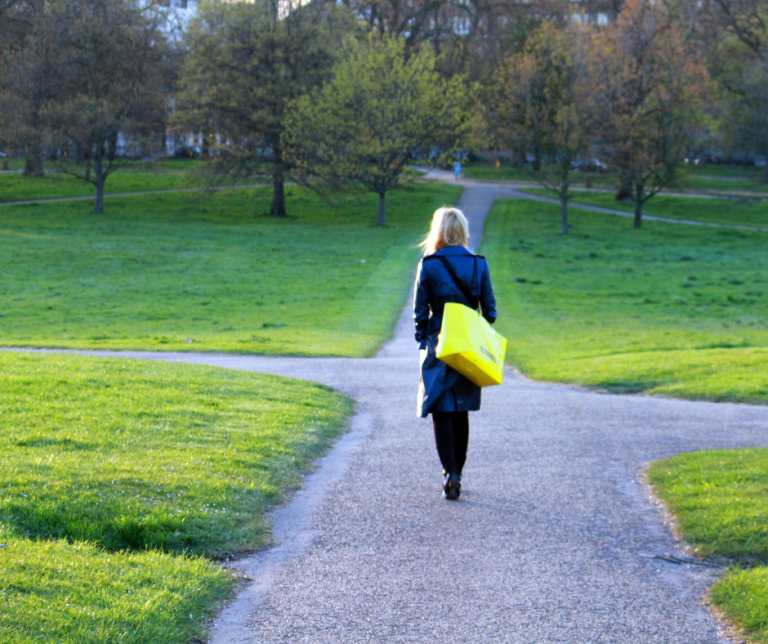 Woman walking in the park, at the crossroads