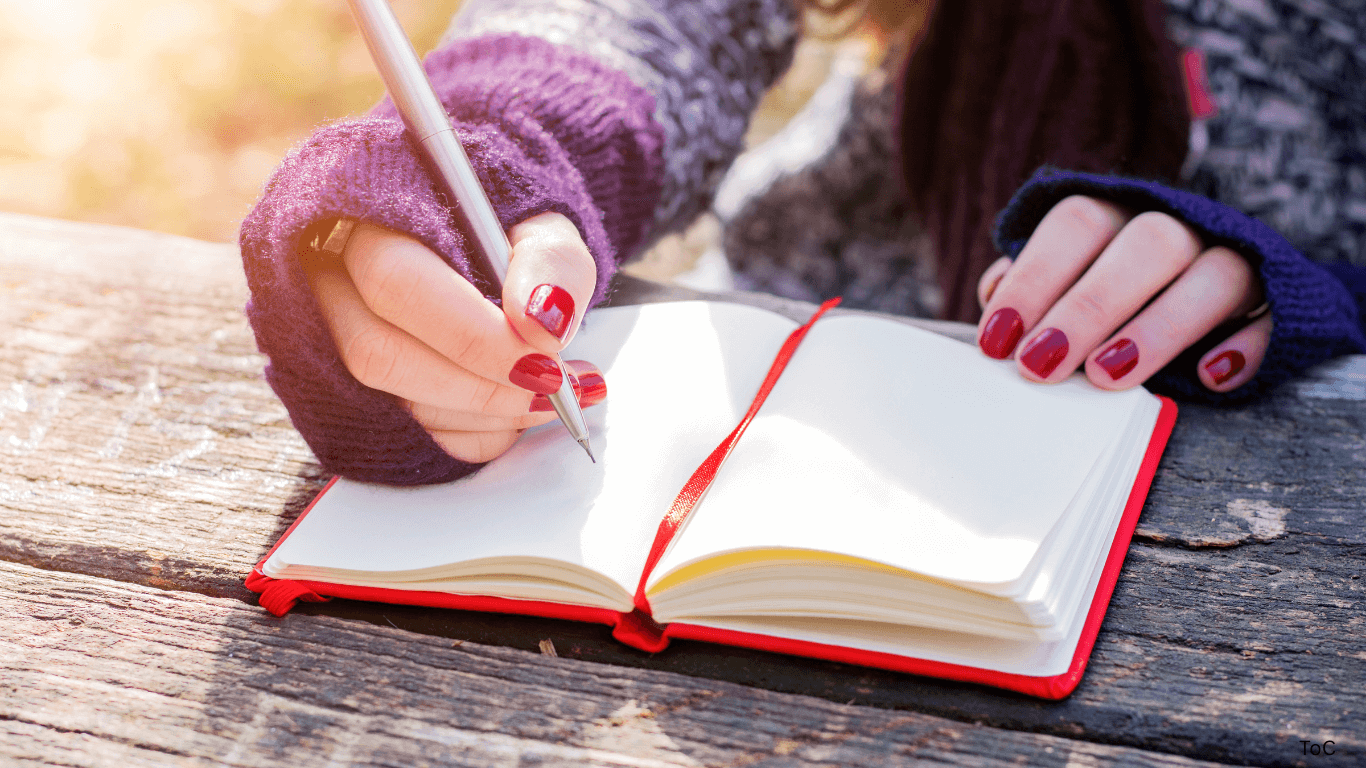 Photo of a woman writing in a journal