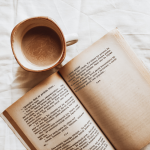 Photo of an open book and a coffee cup representing best habit books